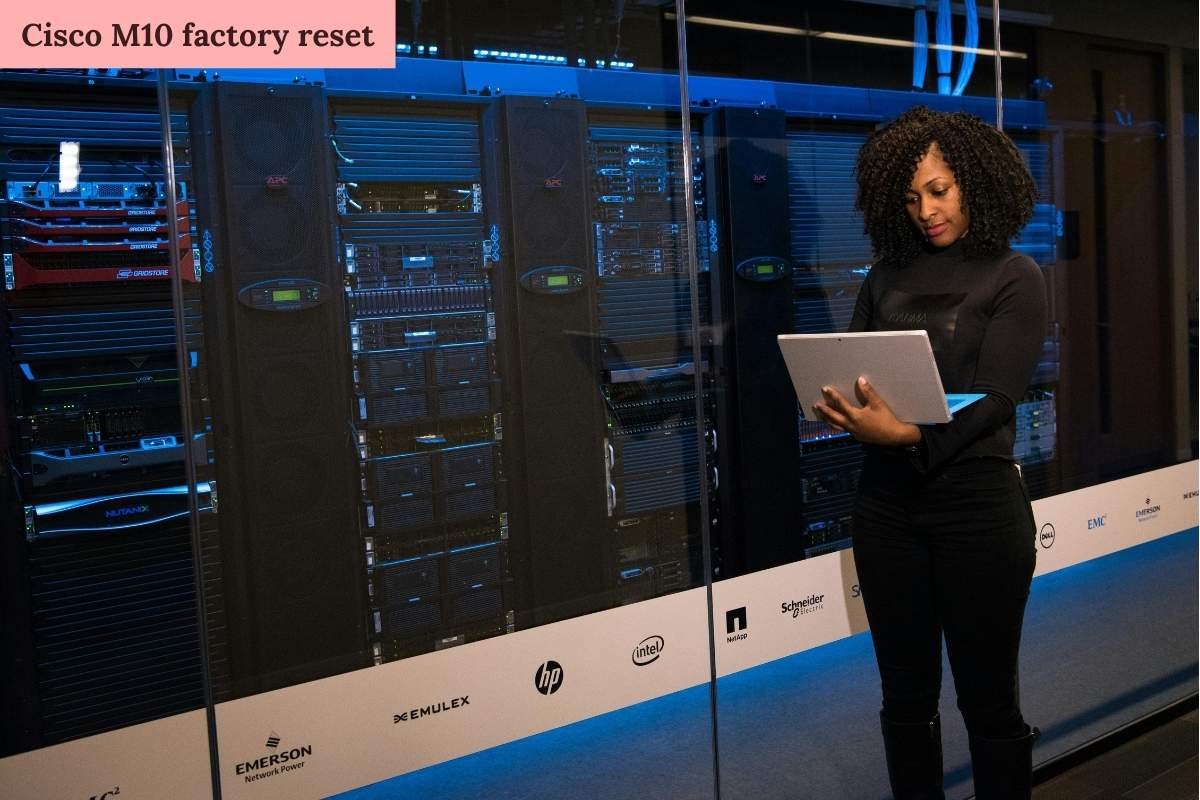 IT professional using a laptop to manage Cisco M10 factory reset in a data center