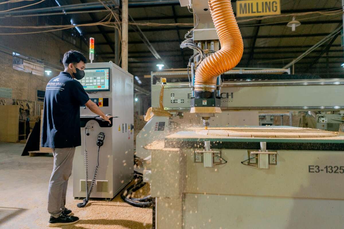 Technician operating a milling machine equipped with 0533205 Pressure Switch for precise control in a manufacturing facility