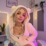 A young woman in cozy hoodie posing indoors with soft lights, styled for Babyfooji Photos Albums Zip theme