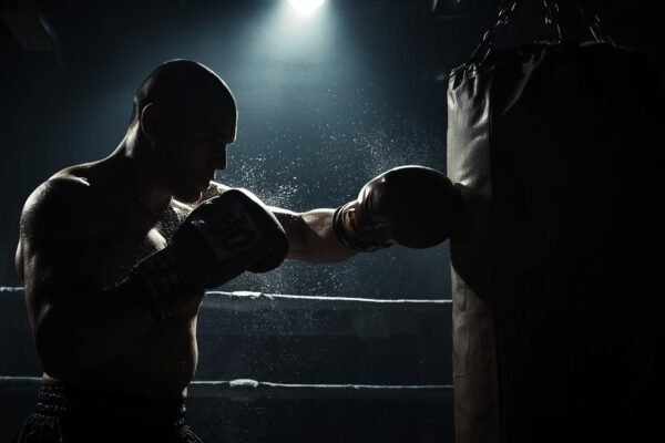 Demetris Fenwick: The Inspiring Rise of a Fighter Demetris Fenwick training hard with punching bag under spotlight in boxing ring