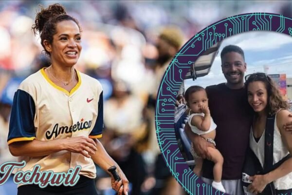 Elle Duncan smiling at a sports event with a family photo of her husband Omar Abdul Ali and their child featured beside her.