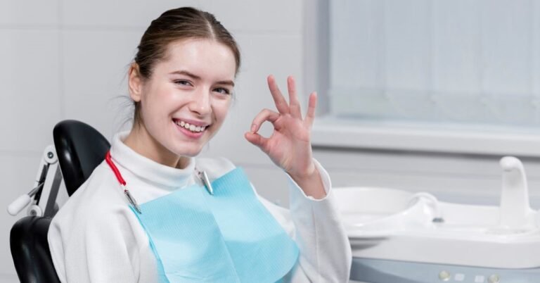 Smiling woman in dental chair showing okay sign, representing positive dental care and healthy gums