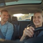 Smooth Learning Central Coast instructor teaching a smiling student driver on a sunny coastal road in Australia.