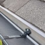 A close-up view of a gutter guard installed on a roof, protecting gutters from debris and ensuring proper water flow, helping to prevent damage to the home.
