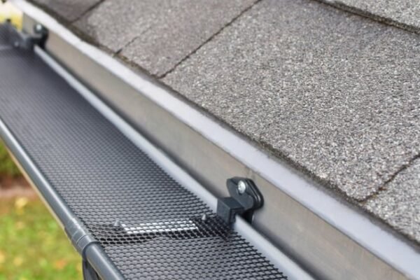 A close-up view of a gutter guard installed on a roof, protecting gutters from debris and ensuring proper water flow, helping to prevent damage to the home.