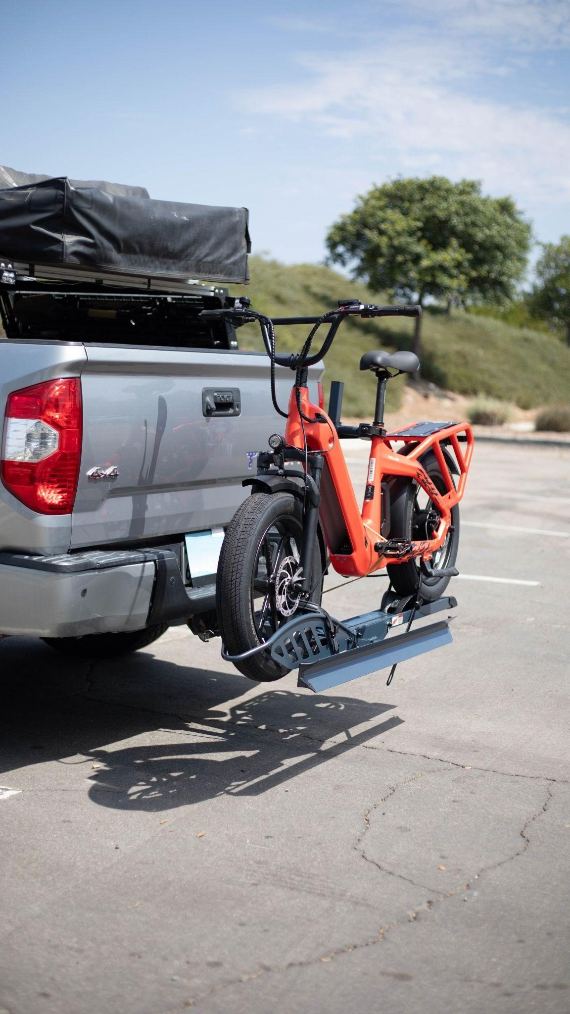 Electric bike mounted on a Hitch Bike Rack attached to a truck, ready for transportation