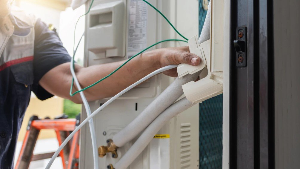 HVAC technician adjusting the air handler system, ensuring proper installation for optimal HVAC performance and energy efficiency