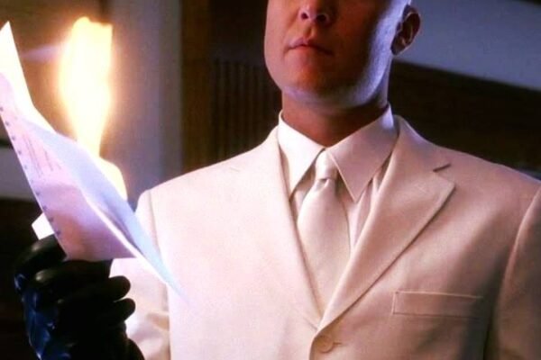 Lex Luthor in Smallville burning a document, showcasing his cold, calculating persona in the series