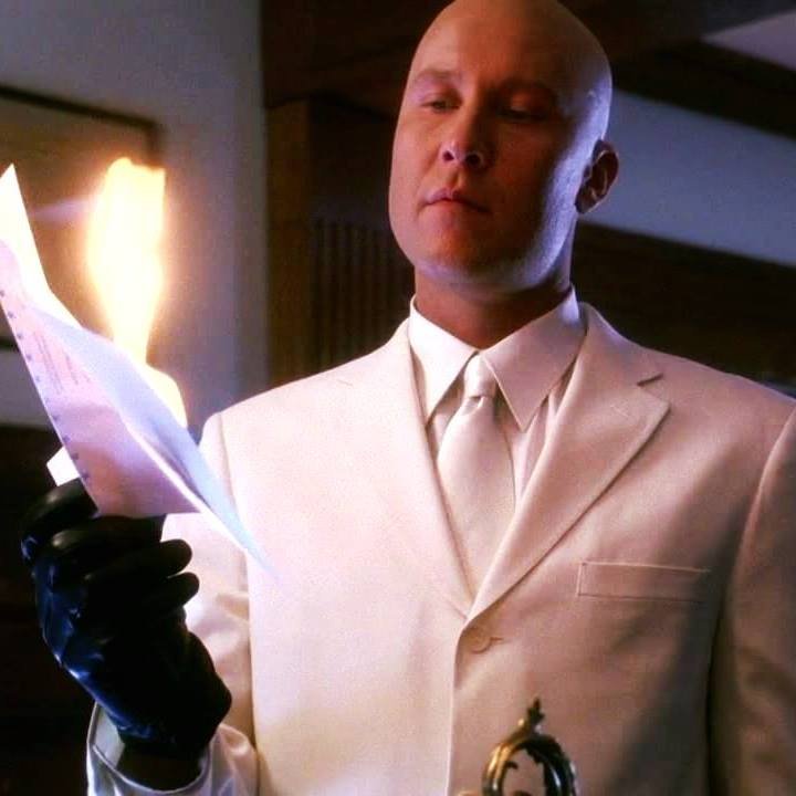 Lex Luthor in Smallville burning a document, showcasing his cold, calculating persona in the series