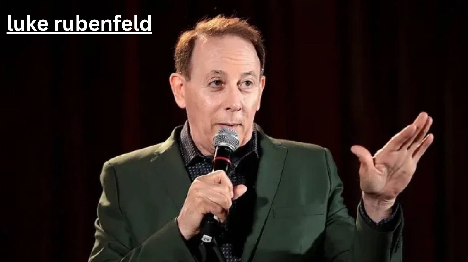 Luke Rubenfeld speaking on stage with a microphone, sharing insights as an experienced dog trainer and canine professional