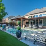 A beautiful backyard featuring a pool, seating area, and lush greenery, showcasing the ultimate in outdoor living space design.
