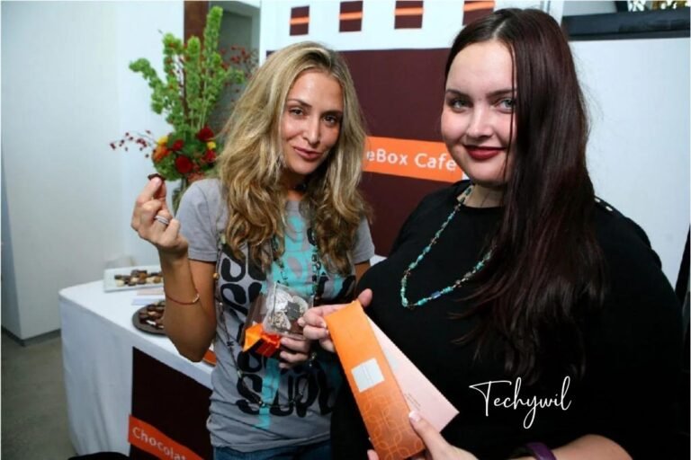 Paula Profit (left) at a Chocolat Box Café event, enjoying a chocolate treat with a guest while promoting her entrepreneurial ventures