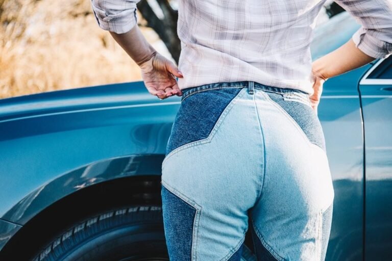 A person adjusting their stretch denim jeans, showing the flattering fit and comfort of this fabric tailored for curvy figures.
