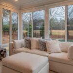 A bright and serene sunroom with vinyl windows showcasing a clear view of the outdoors, offering a quiet and peaceful environment.
