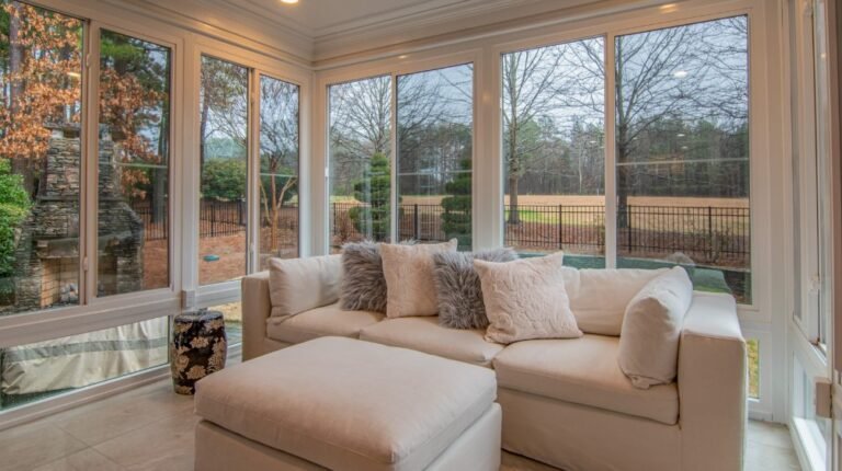 A bright and serene sunroom with vinyl windows showcasing a clear view of the outdoors, offering a quiet and peaceful environment.