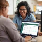 Two employees viewing the Dollar Tree Compass Employee Portal on a laptop, discussing work schedules and updates together in a retail environment