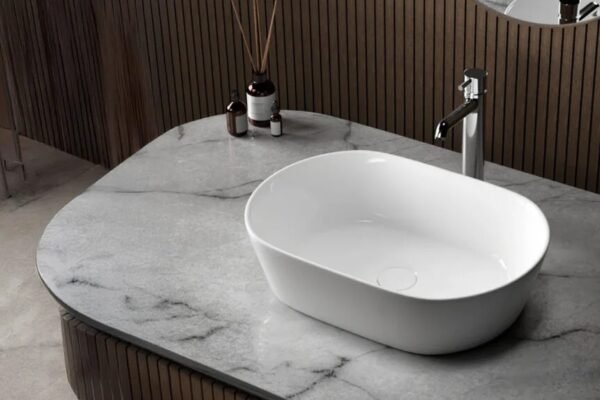 A sleek and modern table top wash basin on a marble countertop, showcasing a minimalist design with a stylish faucet, perfect for contemporary bathrooms