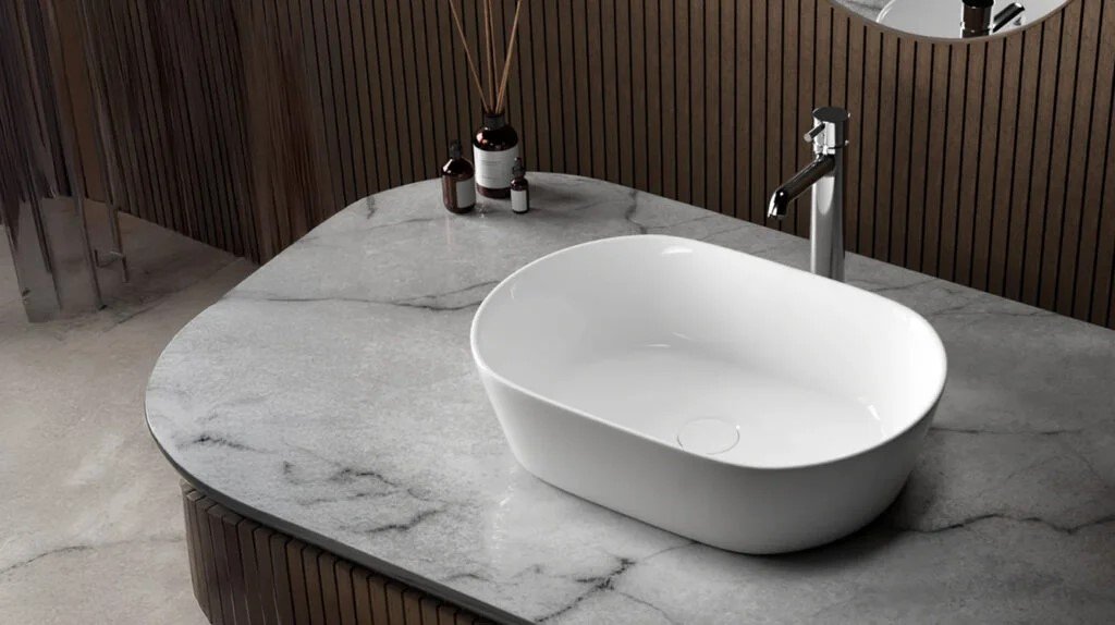 A sleek and modern table top wash basin on a marble countertop, showcasing a minimalist design with a stylish faucet, perfect for contemporary bathrooms