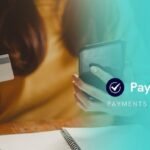 A person holding a credit card and smartphone, using PayChoice for seamless direct debit payments.