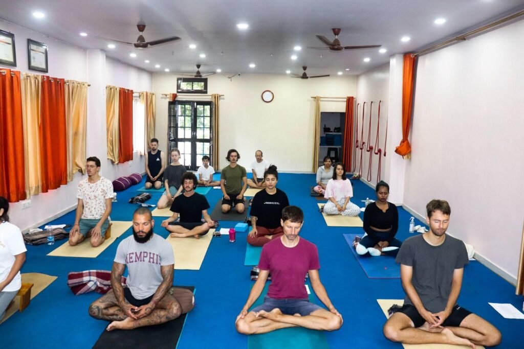 Students practicing meditation during a Yoga Course in Rishikesh, focused on mindfulness and inner peace in a serene yoga studio
