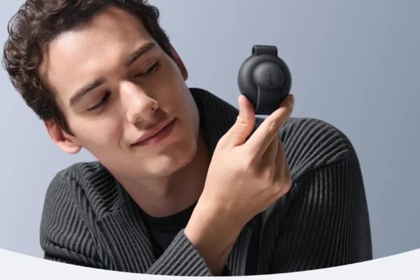 Man holding a compact wireless device demonstrating MagSafe Charger compatibility for iPhone and AirPods charging with magnetic alignment.